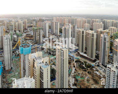 Aerial view of massive building sites in construction with tower crane. Building blocks apartment in construction in developing part of the city of Tianjin in China. Estate construction site. Stock Photo