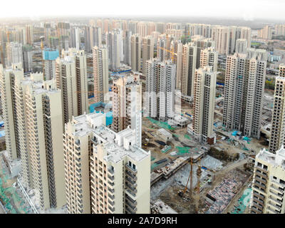 Aerial view of massive building sites in construction with tower crane. Building blocks apartment in construction in developing part of the city of Tianjin in China. Estate construction site. Stock Photo