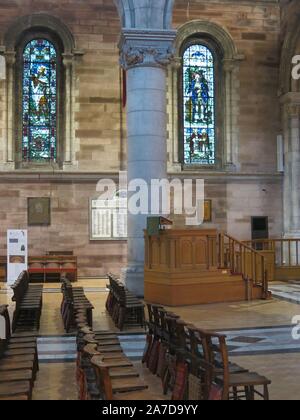 View inside the interior of the Cathedral Church of St Anne, central Belfast: pews, lectern and stained glass windows. Stock Photo