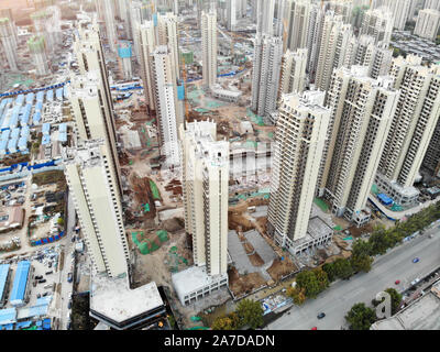 Aerial view of massive building sites in construction with tower crane. Building blocks apartment in construction in developing part of the city of Tianjin in China. Estate construction site. Stock Photo