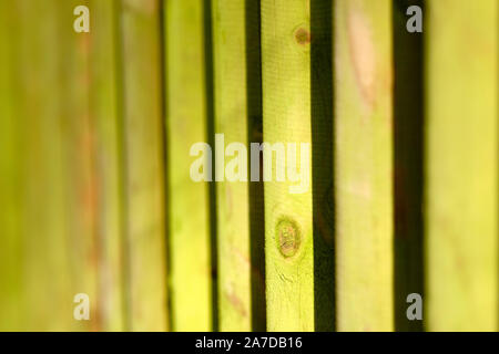 Background with the pattern of a closeup of a green colored wooden fence in the sunlight. Seen in Germany, Bavaria, in October. Stock Photo