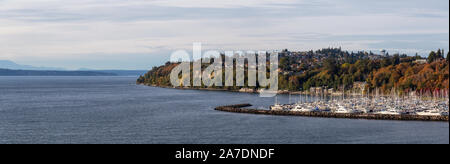 Beautiful Aerial Panoramic View of boats in a Marina on the Ocean Shore during a cloudy autumn evening. Taken in Smith Cove Park, Seattle, Washington, Stock Photo