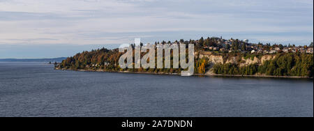 Beautiful Panoramic Aerial View of Residential Homes on the Ocean Shore during a cloudy autumn evening. Taken in Smith Cove Park, Seattle, Washington, Stock Photo