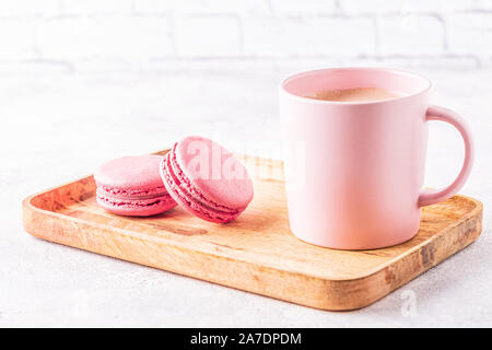French macaroons and cup of coffee on a wooden tray. Stock Photo