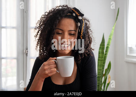 Shot of young latin woman working at home with laptop and documents Stock Photo
