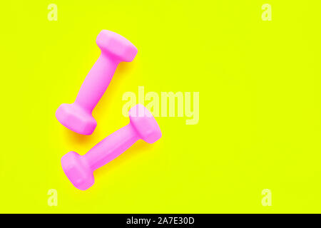 Top view of pink dumbbells isolated on yellow background. Copy space Stock Photo