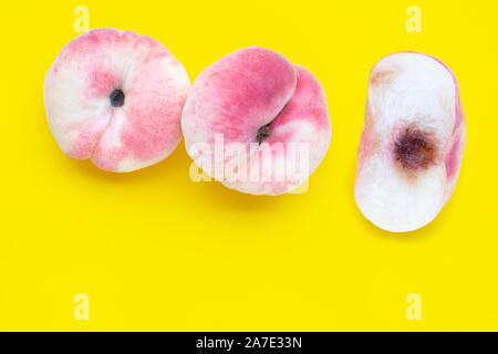 Chinese flat peaches on yellow background. Copy space Stock Photo