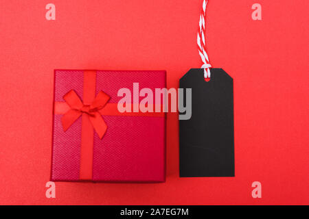 Red tag label and red grift box on black background, blank copy space for you work, Online marketing shopping concept Stock Photo