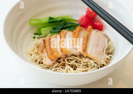 Bowl of noodle with roasted pork on white table. Stock Photo