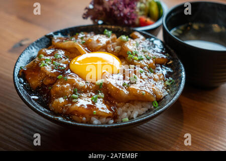 Bowl of Japanese food, grilled pork and egg over rice. Stock Photo