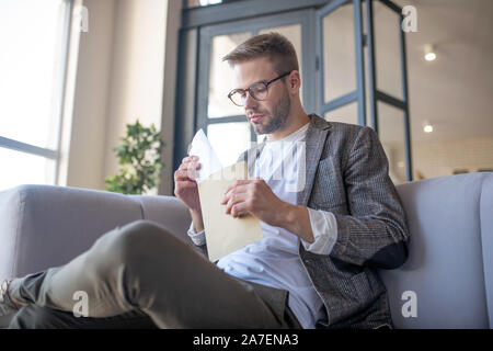 Bearded man in glasses holding envelope with letter Stock Photo