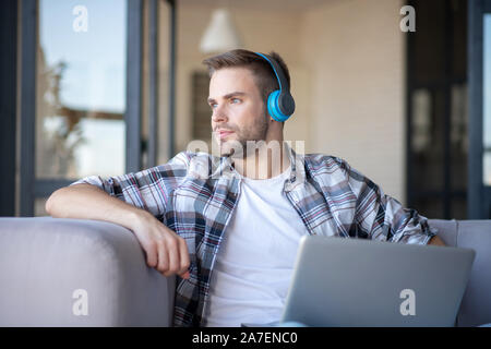 Handsome blue-eyed freelancer feeling good working at home Stock Photo