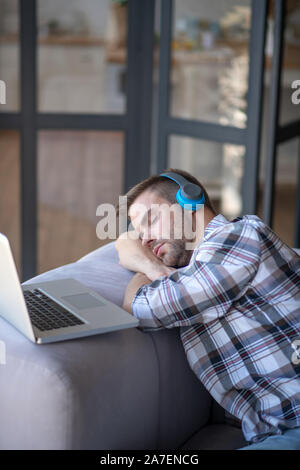 Bearded man wearing checked shirt having a nap after working Stock Photo