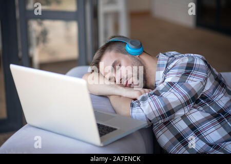 Bearded freelancer falling asleep after working for too long Stock Photo