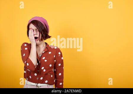 Tired young caucasian yawning looks bored, covering half face with hand. Stock Photo