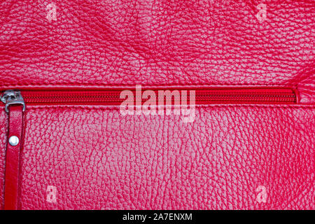 closed red zipper on leather red bag, close-up Stock Photo