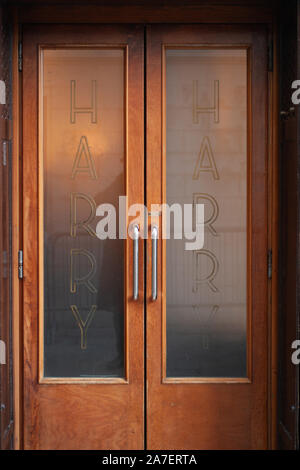 Venice, Italy - December 28 2009: The wooden entrance door with glass panels to world famous Harry's Bar in Venice, Italy. Stock Photo