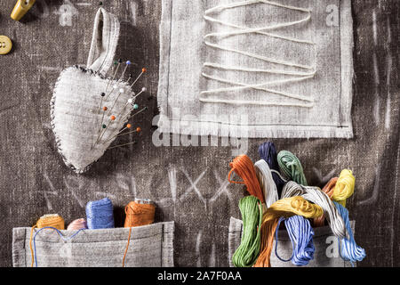 Colored threads and needles in vintage mat tailor Stock Photo