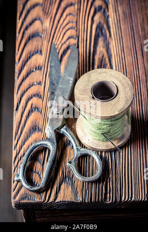 Closeup of vintage scissors and threads on wooden table Stock Photo