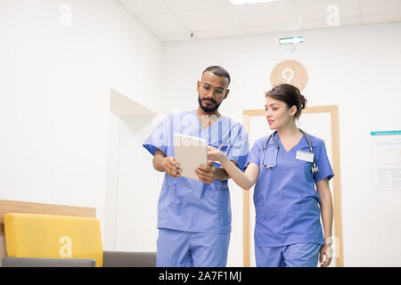 One of two clinicians making presentation or explaining something to colleague Stock Photo