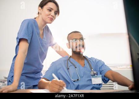 Successful clinicians looking at computer screen while working over new project Stock Photo