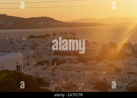 Beautiful sunset over little venice  with windmills bathing in golden light Mykonos , Greece Stock Photo