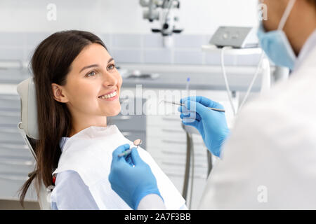 Pretty woman looking at dentist with trust Stock Photo
