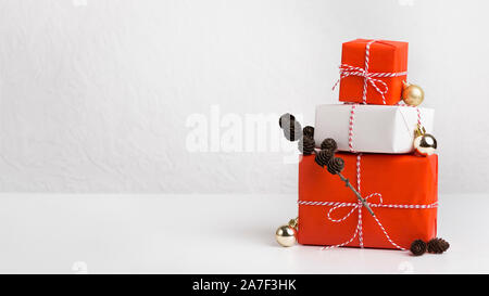 Gift boxes of red and white paper decorated by cones Stock Photo