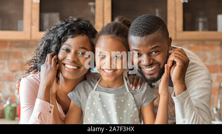Portrait of happy family over kitchen background Stock Photo