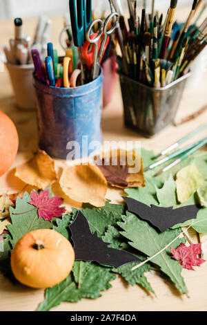 Composition of dry leaves, black paper bats, small pumpkin and other stuff Stock Photo