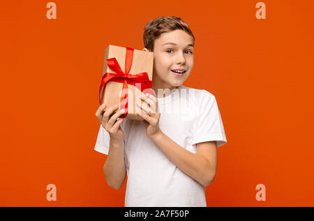 Curious teen boy checking gift, shaking present box Stock Photo