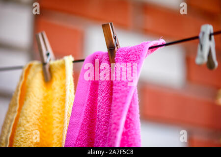Two towels with clothespins hanging on clothesline outdoors. Close up. Stock Photo