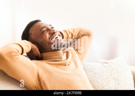 Happy Black Guy Relaxing Sitting On Couch At Home Stock Photo