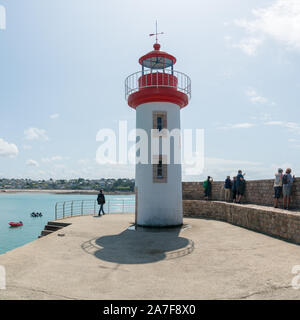 Erquiy, Cotes-d-Armor / France - 20 August, 2019: tourists visit the old port and lighthouse of Erquy on the coast of Brittany Stock Photo