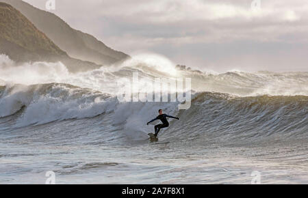 Swansea, UK. 02nd Nov, 2019. A surfer rides the waves at Langland Bay near Swansea this morning. The waves were generated by the stormy weather which battered South Wales last night. Credit: Phil Rees/Alamy Live News Stock Photo