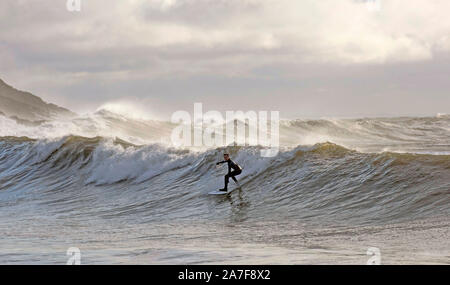 Swansea, UK. 02nd Nov, 2019. A surfer rides the waves at Langland Bay near Swansea this morning. The waves were generated by the stormy weather which battered South Wales last night. Credit: Phil Rees/Alamy Live News Stock Photo