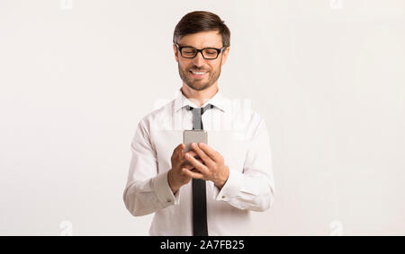 Smiling Man Texting On Cellphone Over White Background Stock Photo