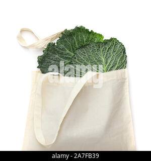 Green cabbage leaves in white cotton reusable shopping bag Stock Photo