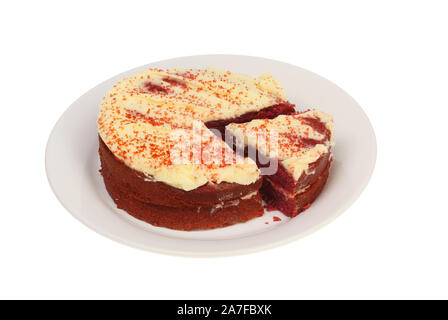Red velvet cake on a plate with a slice cut out on a plate isolated against white Stock Photo