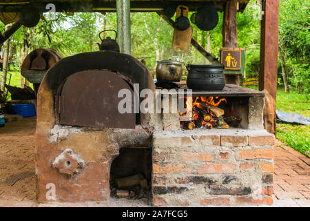 Comandante Andresito, Argentina - Circa October 2019: Soup cooking in a black iron pot on an old style wooden stove at an outdoor kitchen Stock Photo