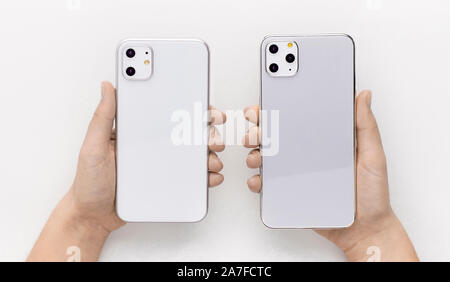 Comparison of two new models of IPhone 11 in hands Stock Photo