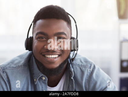 Portrait of friendly black customer support manager in headset Stock Photo