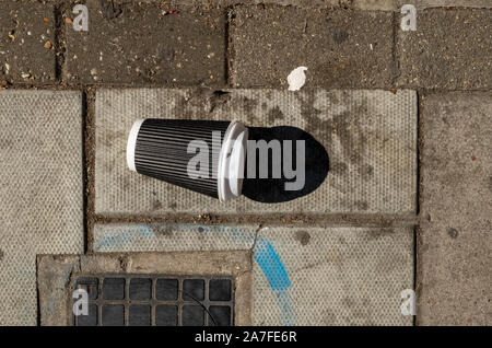 Discarded take out coffee cup on a street in West London UK Stock Photo