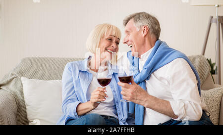 Happy retirement. Loving senior couple relaxing with wine Stock Photo