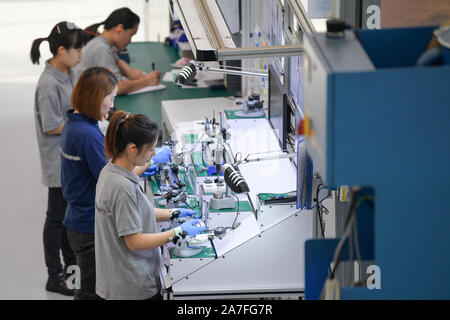 Taicang, China's Jiangsu Province. 31st Oct, 2019. Workers assemble automobile parts in a factory of IMS Gear in Taicang, east China's Jiangsu Province, Oct. 31, 2019. Taicang has been making great efforts to improve business environment through facilitating administrative procedures for enterprises including registration, project approval and tax registration in recent years. As a result, Taicang has attracted investment of over 1,500 foreign enterprises. Credit: Li Bo/Xinhua/Alamy Live News Stock Photo
