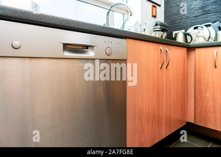 Modern wooden kitchen drawers cabinets and dishwasher with utensils, equipment and nobody Stock Photo