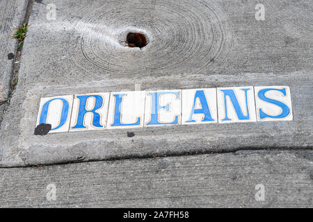 Historic old town Orleans street sign on sidewalk pavement in New Orleans, Louisiana famous town city during day flat top view down Stock Photo