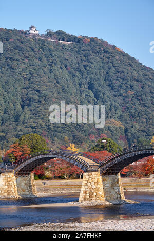 The view of the historical wooden Kintai arch bridge over Nishiki river and Iwakuni Castle on mount in the fall, Iwakuni, Yamaguchi prefecture, Japan Stock Photo