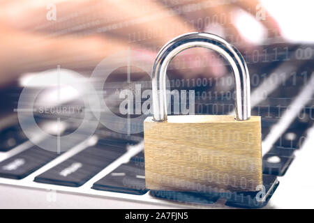 Concept of digital security and cryptology system - digital holograms and closed padlock on the laptop and female hands typing on a keyboard in the ba Stock Photo