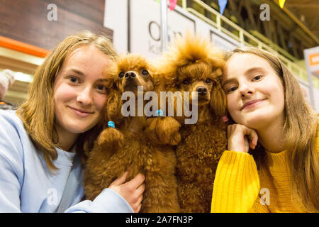 Birmingham, UK. 2nd November, 2019. 16-year-old Greta Bojaroviciute and her sister Gabriele, 13, with miniature poodles Nutta and Esme at the National Pet Show being held at the NEC at the weekend. Hundreds of animals, small and large, farmyard and exotic, furry and feathered, are on show and performing in exhibitions. Peter Lopeman/Alamy Live News Stock Photo